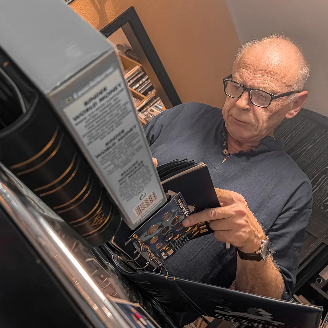 Inhaber und Experte Robert Mensinger liest in einem Katalog